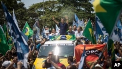 Aecio Neves, Brazilian Social Democracy Party presidential candidate, top center, greets supporters while campaigning at Copacabana beach in Rio de Janeiro, Brazil, Oct. 19, 2014. 