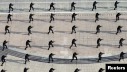 FILE - Police from the Special Weapons and Tactics (SWAT) team take part in an anti-terrorist drill in Dongying, Shandong province, July 11, 2014.