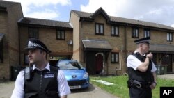 Polisi di luar rumah yang digrebek di Straford, London sebelah timur (5/7).