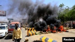Les manifestants soudanais brûlent des pneus et bloquent la route menant au pont al-Mek Nimir qui passe sur le Nil Bleu. qui relie Khartoum Nord et Khartoum, au Soudan, le 13 mai 2019.

