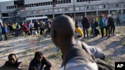 Migrants line up as they wait to be evacuated from a makeshift street camp, in Paris, France, July 7, 2017.
