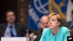German Chancellor Angela Merkel listens to Chinese President Xi Jinping's speech during the opening ceremony of the G20 Leaders Summit in Hangzhou, Sept. 4, 2016. 