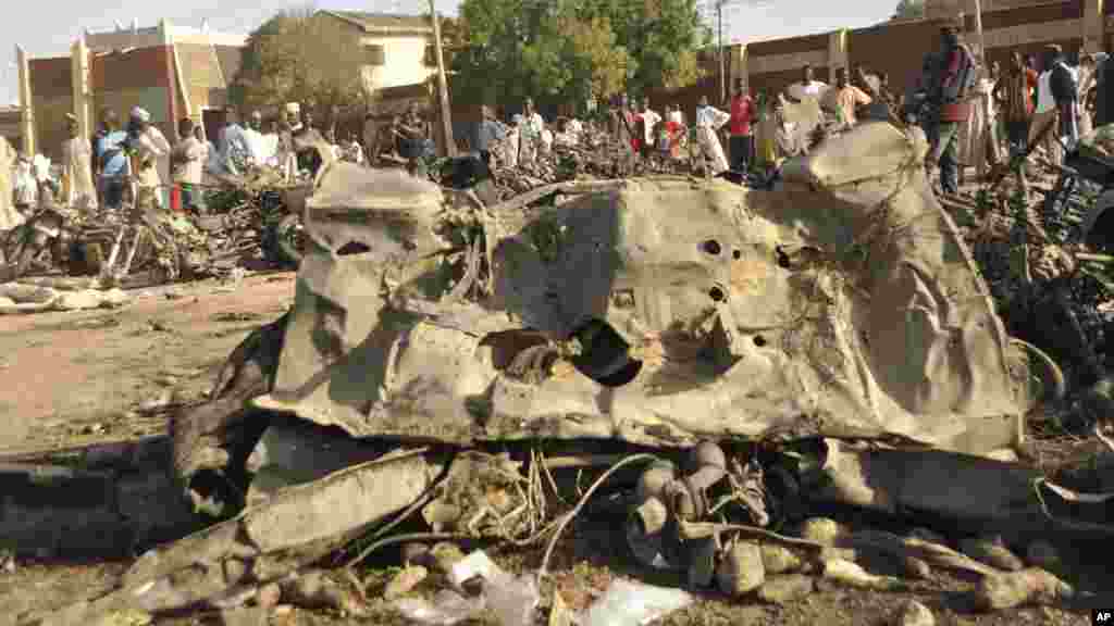 Mutane sun taru su na kallo a inda bam ya tashi a babban Masallacin Jumma'a na Kano, Jumma'a 28 Nuwamba, 2014. Mutane da yawa sun rasa rayukansu, kuma jami'ai suka ce watakila yawan wadanda zasu hallaka zai karu.