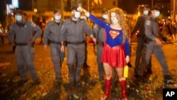 Para petugas kepolisian berusaha menghalau seorang pedemo dalam unjuk rasa memprotes Perdana Menteri Benjamin Netanyahu di luar kediamannya di Yerusalem, Israel, 9 Agustus 2020. (Foto: AP)