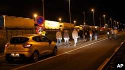 A car of the security society of Eurotunnel follows a group of migrants in Calais, France, July 29, 2015.
