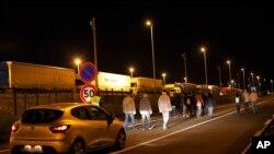 Un véhicule de sécurité de la société Eurotunnel avance derrière un groupe de migrants, à Calais, dans le nord de la France, le 29 juillet 2015.