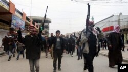 Mourners, Sunni gunmen chant slogans against Iraq's Shiite-led government during funeral of a man killed in clashes between al-Qaida gunmen, Iraqi troops, Fallujah, Jan. 4, 2014.