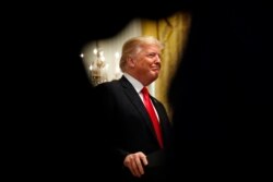 FILE - President Donald Trump smiles as he is applauded while speaking about taxes, June 29, 2018, during an event in the East Room of the White House in Washington.