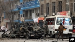 FILE - Afghan security personnel inspect the site of a bomb attack in Kabul, Afghanistan, Dec. 26, 2020. 