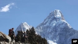 FILE - Trekkers make their way to Dingboche, a popular Mount Everest base camp, in Pangboche, Nepal, Feb. 19, 2016. Officials say three foreign climbers along with three Nepalese guides have scaled Mount Everest, the first foreigners to reach the summit in two years.