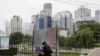 FILE - A security guard mans his post across from the central business district in Beijing, China, Oct. 5, 2021.