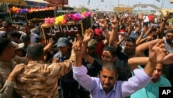 Mourners carry the coffins of two people, killed in protests at Baghdad's International Zone on Friday, during their funeral procession at the holy shrine of Imam Ali, in Najaf, 160 kilometers south of Baghdad, Iraq, May 21, 2016. 