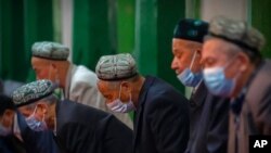 FILE - Uyghurs and other members of the faithful pray during services at the Id Kah Mosque in Kashgar in western China's Xinjiang Uyghur Autonomous Region, as seen during a government-organized visit for foreign journalists, April 19, 2021. 