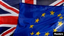 FILE - A British Union Jack flag and a European flag fly on the Amiens city hall during a Franco-Britain summit in Amiens, northern France, March 3, 2016. 