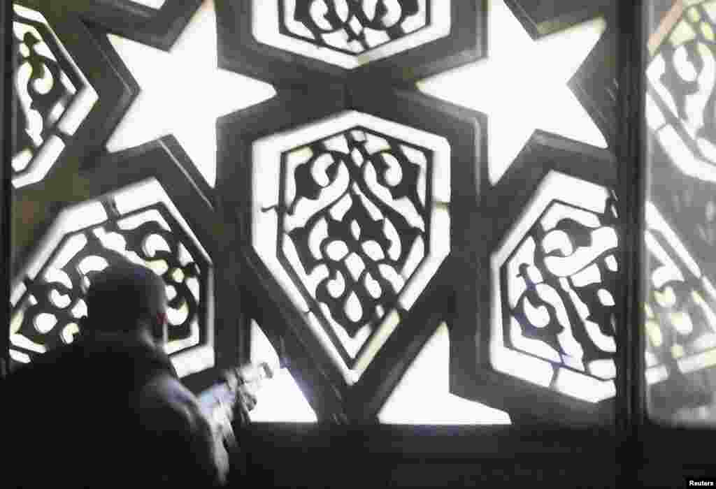 A police officer takes position during clashes with supporters of deposed Egyptian President Mohamed Morsi inside a room of al-Fath mosque in Cairo, August 17, 2013.