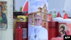 Candles are laid at the statue of John Paul II outside the Gemelli University Hospital where Pope Francis is hospitalized with pneumonia, in Rome, Italy, March 02, 2025.