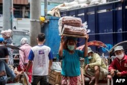 Seorang buruh panggul perempuan sedang bekerja di sebuah pasar di Surabaya, 8 Maret 2021. Setelah 19 tahun pemberlakukan Undang-Undang Penghapusan Kekerasan dalam rumah tangga (KDRT), angka kasus KDRT tetap tinggi. (Foto: Juni Kriswanto/AFP)