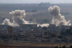 Smoke and dust billow from targets in Ras al-Ayn, Syria, caused by bombardment by Turkish forces, Oct. 15, 2019.
