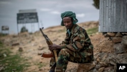 FILE - A fighter loyal to the Tigray People's Liberation Front (TPLF) mans a guard post on the outskirts of the town of Hawzen, May 7, 2021.
