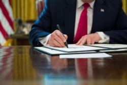 FILE - President Donald Trump signs an executive order to increase sanctions on Iran, at the White House, June 24, 2019.