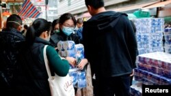 A customer holds toilet paper at a market, following the outbreak of a new coronavirus, in Hong Kong, China February 8, 2020. 