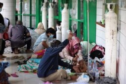 Oxygen tanks are prepared for patients in the hallway of an overcrowded hospital amid a surge of COVID-19 cases, in Surabaya, East Java, Indonesia, July 9, 2021.