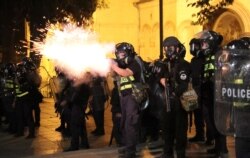 A riot policeman fires during a rally against a Russian lawmaker's visit in Tbilisi, Georgia, June 21, 2019.