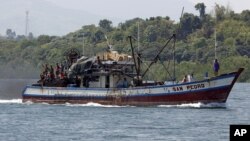 Filipino fishermen wave from a fishing boat bound to fish near Scarborough Shoal in Masinloc, Zambales May 10, 2012. 