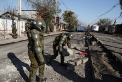 Police clear a barricade during clashes demanding food aid from the government during the COVID-19 lockdown, at a poor neighborhood in Santiago, Chile, Monday, May 18, 2020.