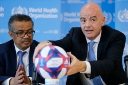 FILE - Director-General of the World Health Organization Tedros Adhanom Ghebreyesus and FIFA President Gianni Infantino attend a press conference at WHO headquarters, Geneva, Switzerland, Oct. 4, 2019.