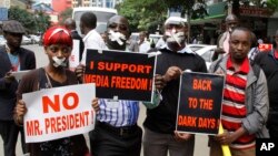 FILE - Kenyan journalists wear tape over their mouths to signify being silenced, Dec. 3, 2013.