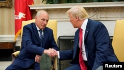 Presiden Donald Trump berjabat tangan dengan John Kelly setelah dia dilantik sebagai Kepala Staf Gedung Putih di Ruang Oval di Gedung Putih, Washington, 31 Juli 2017.