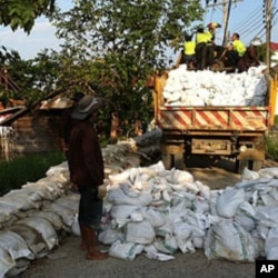 Thai Flood Volunteers Unload Sandbags in Front of Flooded Temple at North Edge of Bangkok