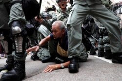 An anti-government protester is detained during a demonstration at Causeway Bay district in Hong Kong, Sept. 29, 2019.
