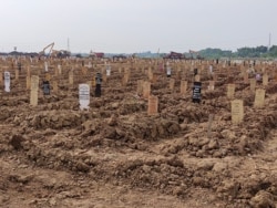 Makeshift grave markers are seen at a cemetery for COVID-19 victims in TPU Rorotan, north Jakarta, Indonesia, July 8, 2021. The 8,000 square meter plot of land, which saw its first funerals in March, is now almost full. (Indra Yoga/VOA Indonesian)