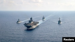 资料照片: 参加“铁拳24”的美国海军两栖攻击舰“美利坚号”(USS America)(中)2020年4月18日与澳大利亚大型护卫舰帕拉马塔号(HMAS Parramatta)，邦克山号航空母舰(USS Bunker Hill)和巴里号驱逐舰(USS Barry DDG-52)在南中国海海域举行演习