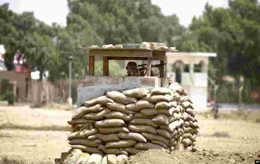 A security guard stands alert outside a training center for airport security personnel after an attack in Karachi, Pakistan, Tuesday, June 10, 2014