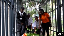 FILE - Members of Emergency Rescue Services place flowers during the reopening ceremony of the DusitD2 hotel, in Nairobi, Kenya, July 31, 2019, six months after the terror attack that left 21 people dead.
