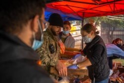 Local volunteers gather food, medicine and clothes to send to families displaced by the conflict in Nagorno-Karabakh, in Yerevan, Armenia on Oct. 6, 2020. (Yan Boechat/VOA)