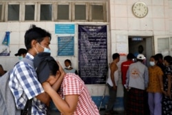 Relatives of anti-coup protester victims wait outside the morgue for the return of their bodies at Thingangyun Hospital in Yangon, Myanmar, March 15, 2021.