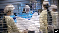 FILE - In this image provided by University of Utah Health, medical professionals look after a COVID-19 patient in the intensive care unit on July 30, 2021, in Salt Lake City.