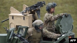 FILE - U.S. soldiers sit in a tank during a military exercise in Grafenwoehr, Germany, May 12, 2017.