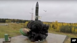 In this photo taken from undated footage distributed by Russian Defense Ministry Press Service, an intercontinental ballistic missile lifts off from a silo somewhere in Russia.
