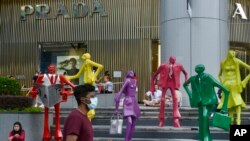 Orang-orang mengenakan masker saat berjalan di area perbelanjaan Orchard Road di Singapura pada 28 November 2021. (Foto: AP/Annabelle Liang)