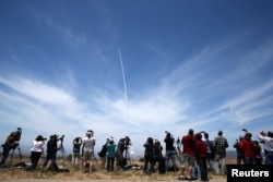 FILE - People watch as the Ground-based Midcourse Defense (GMD) element of the U.S. ballistic missile defense system launches during a flight test from Vandenberg Air Force Base, Calif., May 30, 2017.