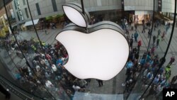 FILE - Consumers line up at an Apple store in Munich after release of a new iPhone model in 2014. A recent European Union tax ruling against Apple points up disparities in how corporations are taxed.