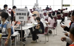 Senior citizens wait to receive a COVID-19 vaccine at a large-scale vaccination center in Osaka, western Japan, May 24, 2021, in this photo distributed by Kyodo.