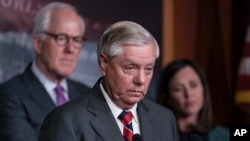 Sen. Lindsey Graham, R-S.C., flanked by Sen. John Cornyn, R-Texas, left, and Sen. Katie Britt, R-Ala., speaks to reporters as they criticize President Joe Biden's policies on the US-Mexico border, at the Capitol in Washington, Thursday, Dec. 7, 2023.