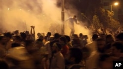 Supporters of Egypt's ousted President Mohammed Morsi run for cover from tear gas fired by riot police during clashes at Nasr City, where protesters have installed their camp and hold their daily rally, in Cairo, Egypt, July 26, 2013.