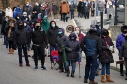 People wait in line at a COVID-19 vaccination site in Paterson, New Jersey, Jan. 21, 2021.